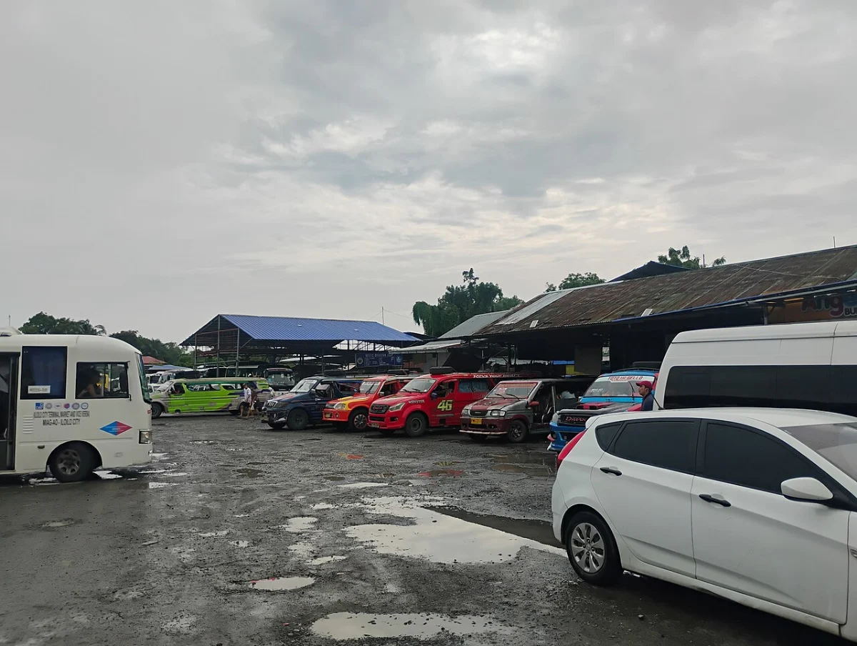 Jeepneys and vans lined up at the Mohon Terminal in Iloilo City, parked in a row under a grey sky
