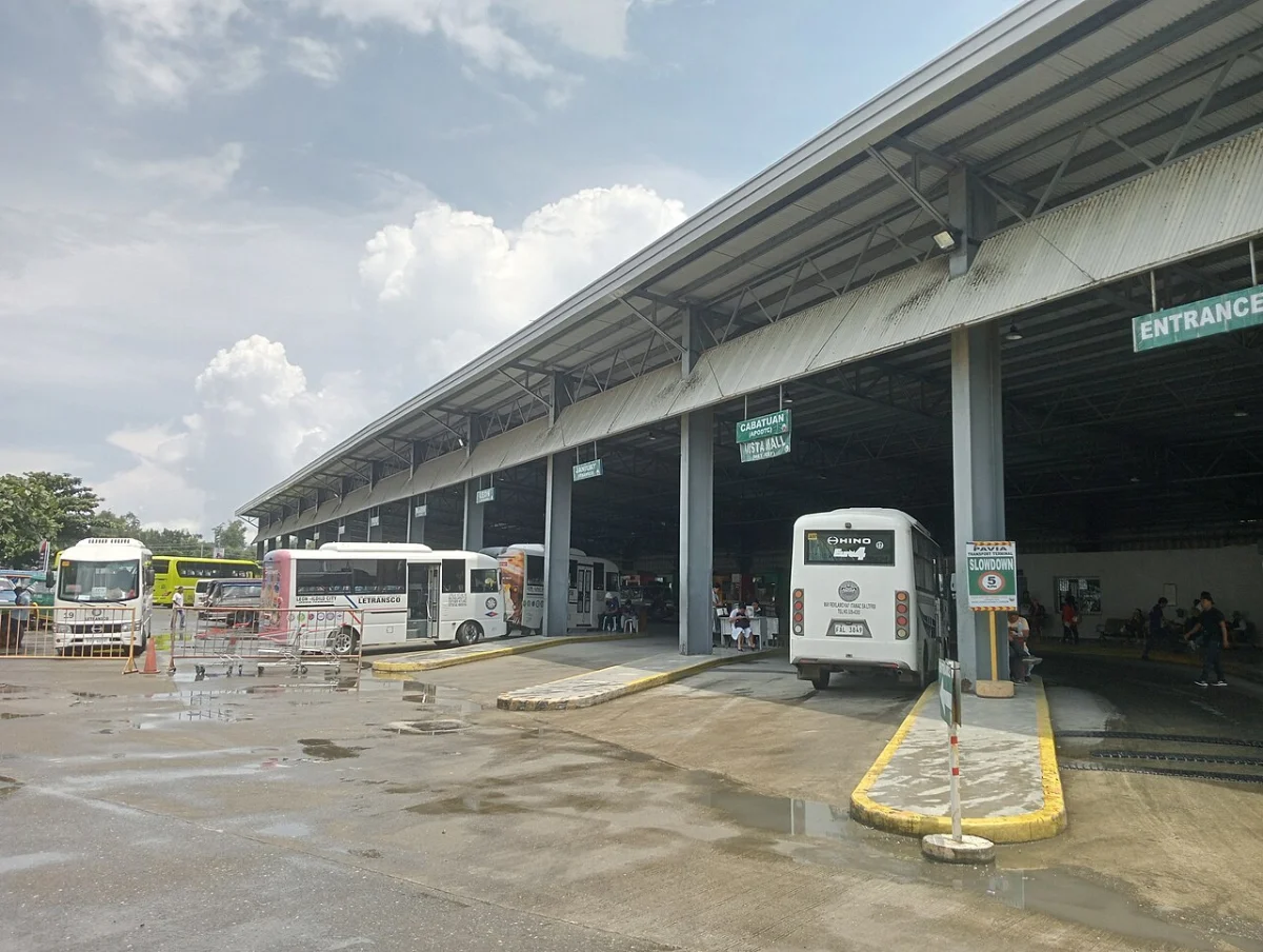 Buses and modern jeepneys under the long roof of the Pavia Transport Terminal in Iloilo